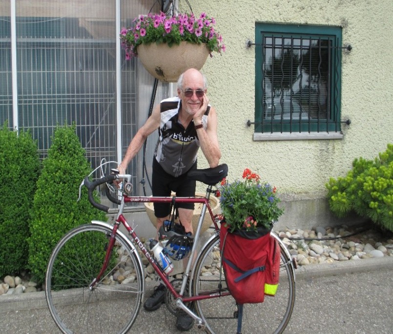 The Rev. Dr. R. Gerald Hobbs, recipient of the Emmanuel College Alumni/ae Service Award, poses with his bicycle.