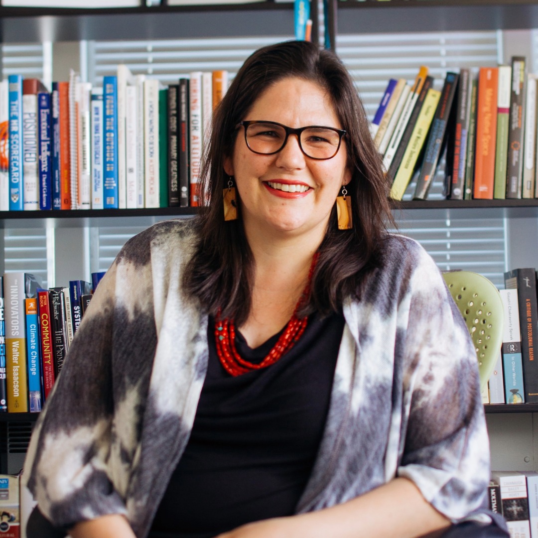 Carmen Lansdowne seated in front of a bookshelf.
