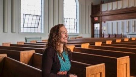 Alexa Gilmour sitting in a church pew. 