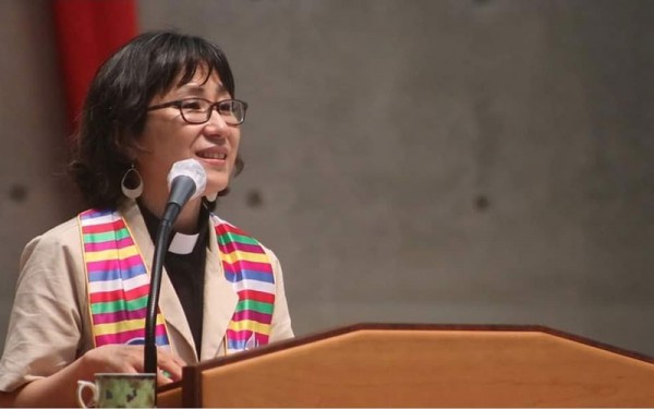 Principal HyeRan Kim-Cragg standing at a podium. 